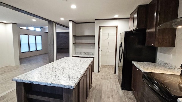 kitchen featuring a center island, light stone counters, light hardwood / wood-style flooring, black appliances, and ornamental molding