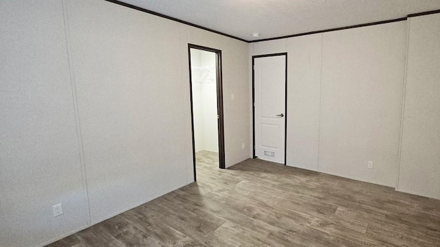 empty room featuring ornamental molding and hardwood / wood-style flooring