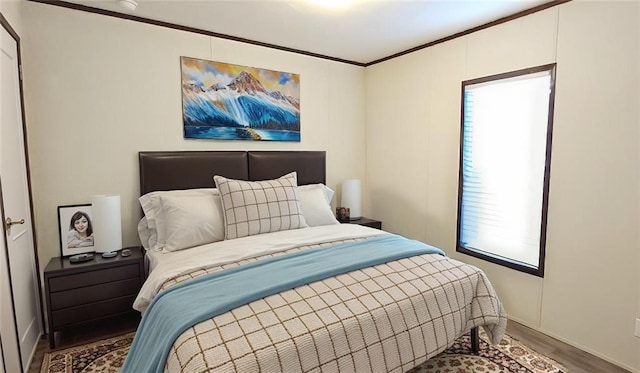 bedroom featuring wood-type flooring, multiple windows, and crown molding