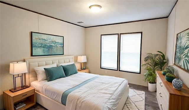 bedroom with dark hardwood / wood-style flooring and ornamental molding