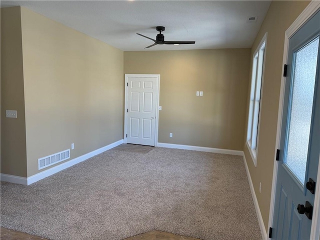 carpeted spare room featuring a wealth of natural light and ceiling fan