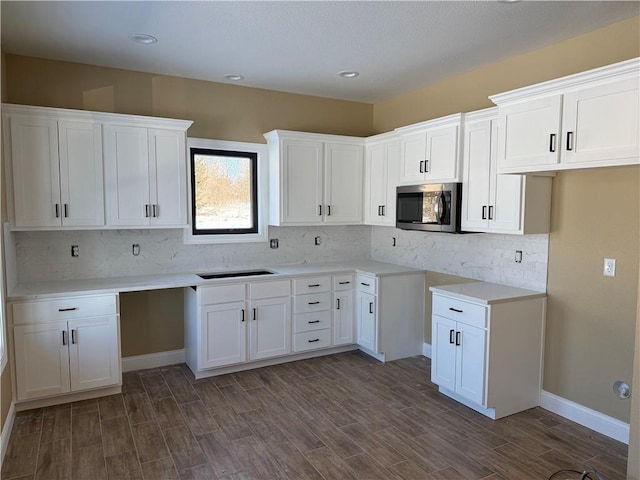 kitchen featuring stainless steel microwave, white cabinets, and dark wood finished floors