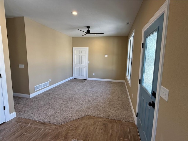 spare room featuring a ceiling fan, carpet, visible vents, and baseboards