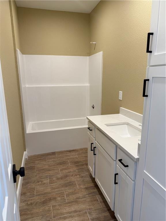 bathroom with  shower combination, wood finish floors, and vanity