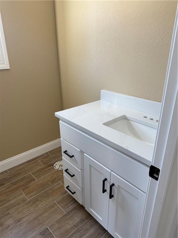 bathroom featuring baseboards, vanity, and wood tiled floor