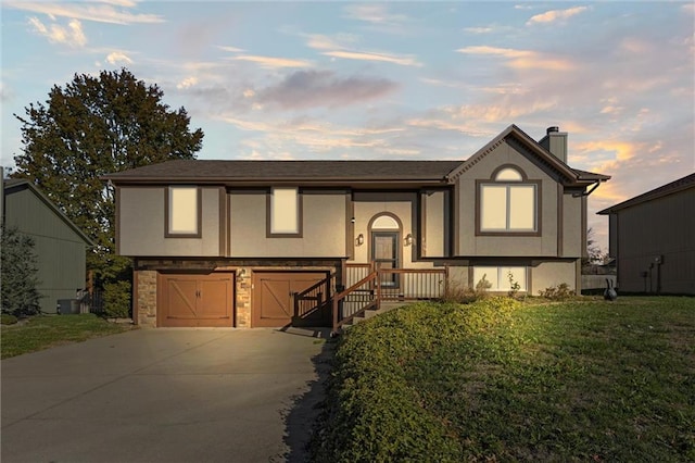 split foyer home with a lawn and a garage