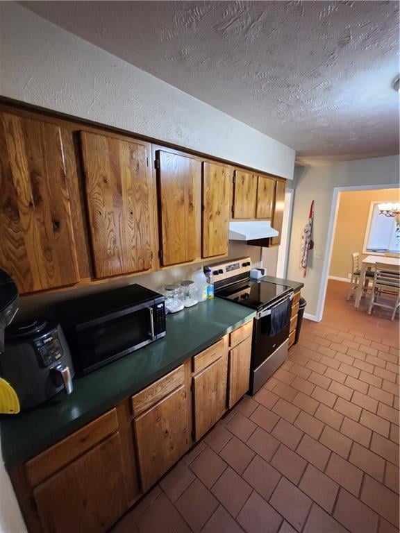 kitchen featuring stainless steel appliances, a textured ceiling, and tile patterned floors