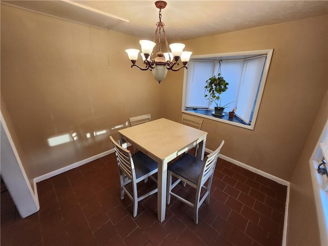 dining room with dark tile patterned floors and a notable chandelier