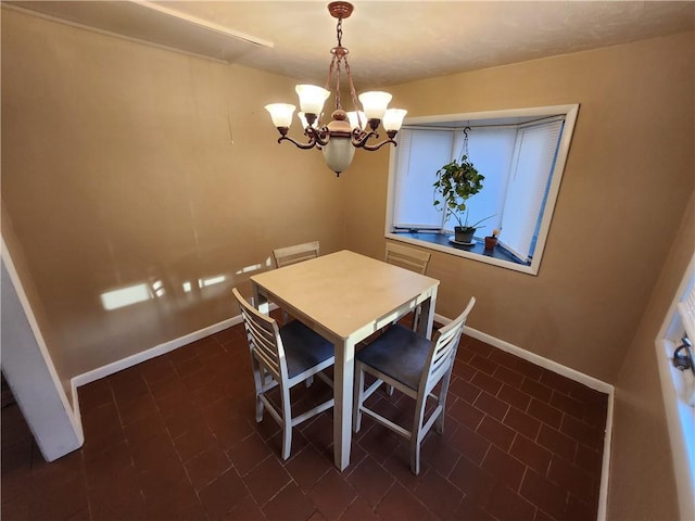 2716 N 10th St, Independence, KS 67301 - dining space with a chandelier, baseboards, and dark tile patterned flooring