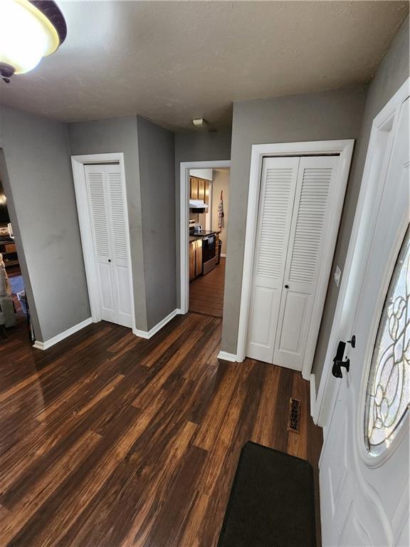 2716 N 10th St, Independence, KS 67301 - foyer with baseboards and dark wood-style flooring
