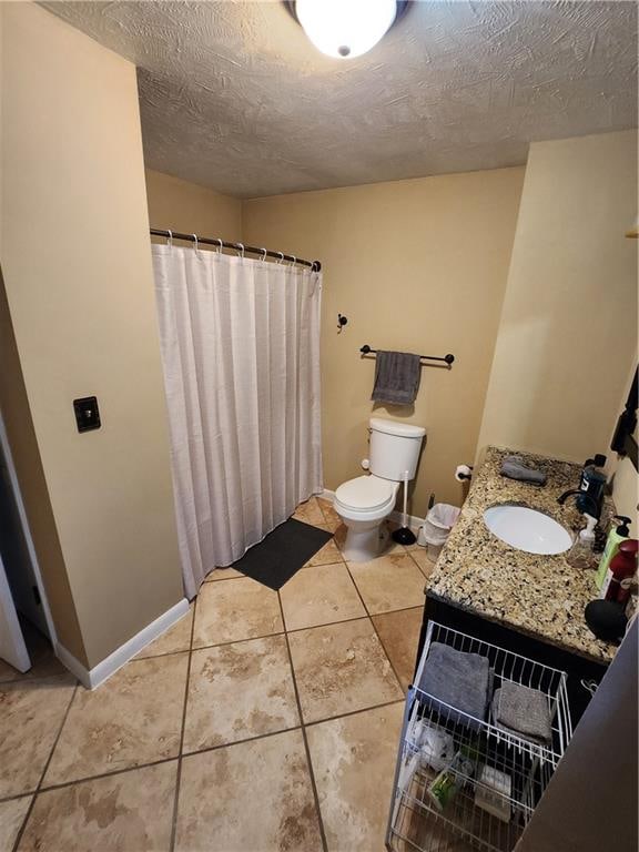 bathroom with vanity, tile patterned floors, toilet, and a textured ceiling