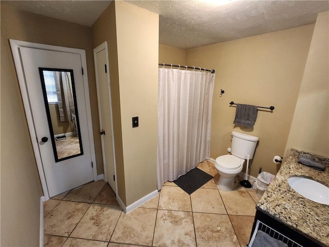 bathroom featuring tile patterned flooring, vanity, a textured ceiling, and toilet