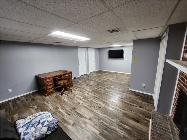 unfurnished office with a drop ceiling and dark hardwood / wood-style floors