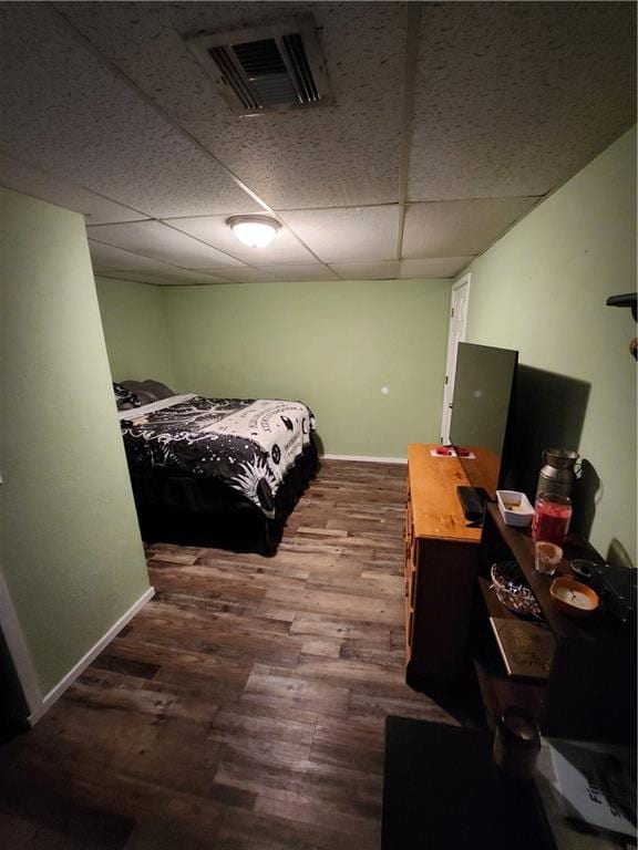 bedroom with a drop ceiling and hardwood / wood-style floors