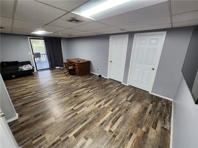 basement featuring dark hardwood / wood-style flooring and a paneled ceiling