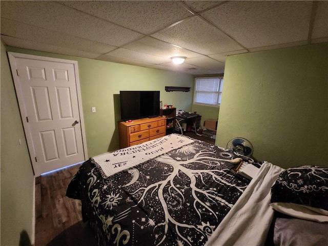 bedroom with dark hardwood / wood-style flooring and a drop ceiling