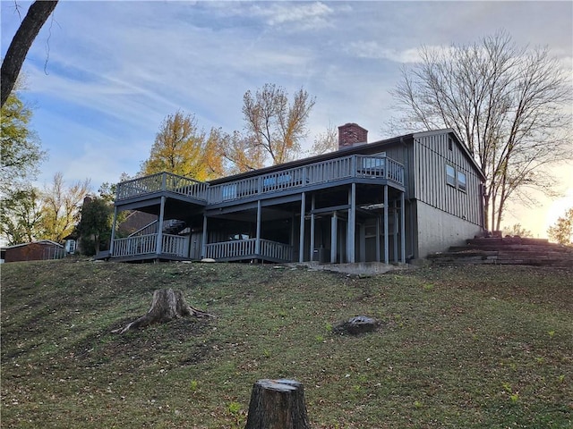 2716 N 10th St, Independence, KS 67301 - rear view of property with a chimney, a deck, and a lawn