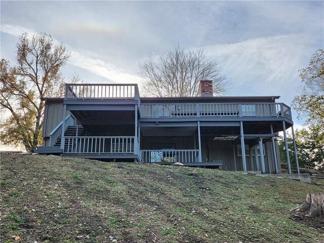 2716 N 10th St, Independence, KS 67301 - back of house featuring a chimney, a deck, and board and batten siding