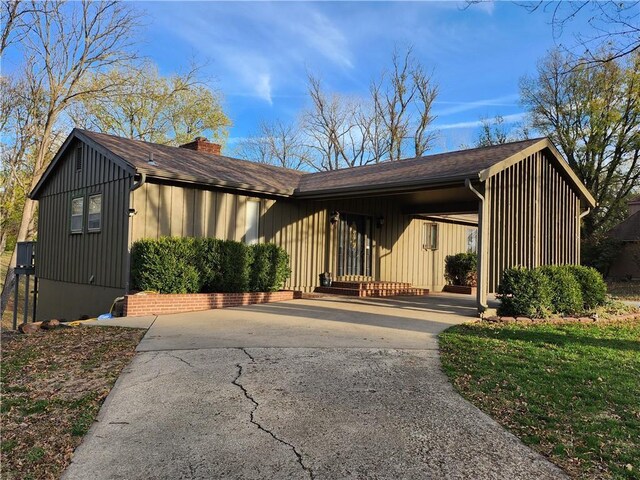 2716 N 10th St, Independence, KS 67301 - view of front of property featuring concrete driveway, a chimney, board and batten siding, and an attached carport