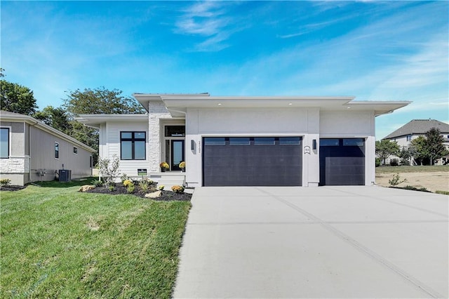 24912 W 98th Pl, Lenexa, KS 66227 - view of front of home featuring a garage, concrete driveway, a front lawn, and central AC