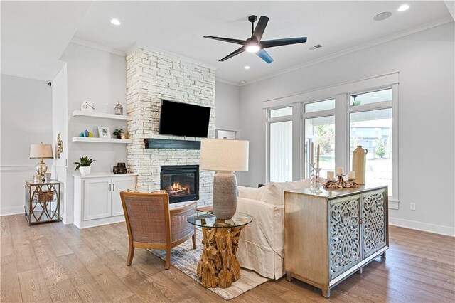24912 W 98th Pl, Lenexa, KS 66227 - living room with light wood-style flooring, a stone fireplace, ornamental molding, ceiling fan, and baseboards