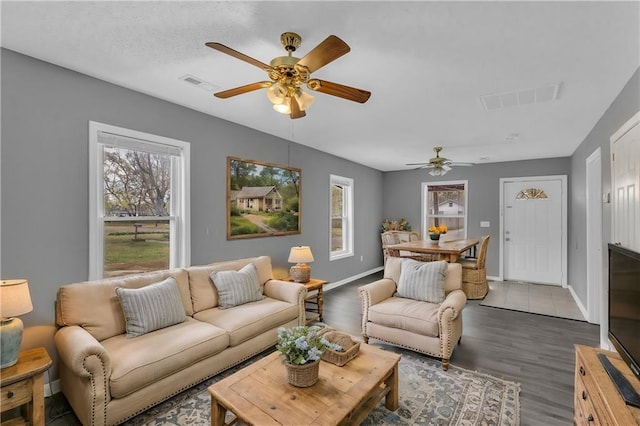 living room with ceiling fan and dark wood-type flooring