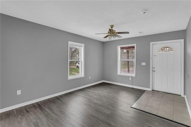 entryway featuring a healthy amount of sunlight, ceiling fan, and dark wood-type flooring