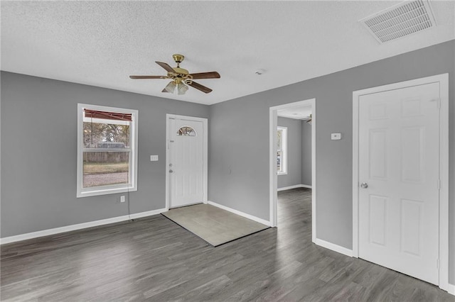 foyer with dark hardwood / wood-style floors, ceiling fan, and a textured ceiling