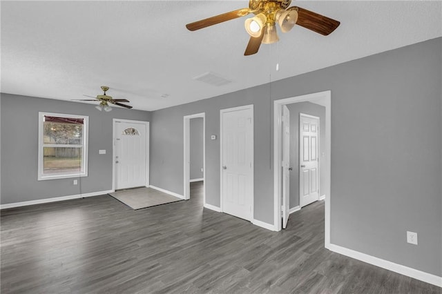 unfurnished living room featuring ceiling fan and dark wood-type flooring