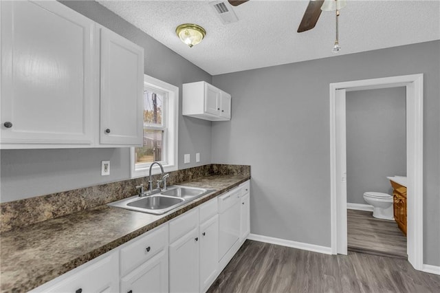 kitchen with sink, dark hardwood / wood-style floors, ceiling fan, a textured ceiling, and white cabinetry