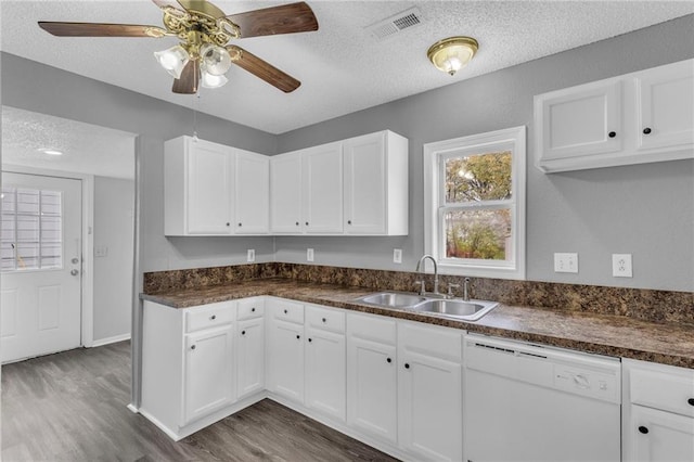 kitchen with dishwasher, white cabinets, a textured ceiling, and sink