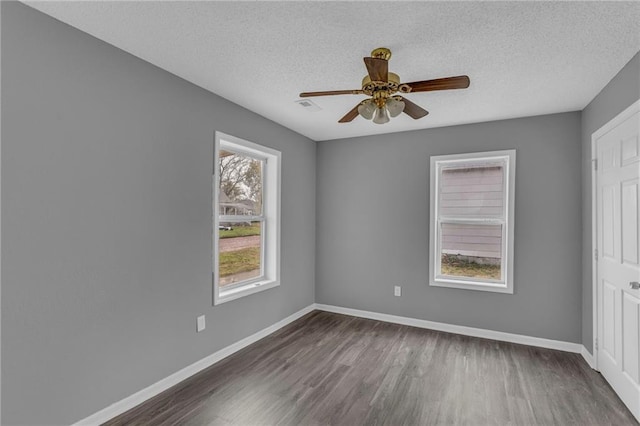 unfurnished room with ceiling fan, dark wood-type flooring, and a textured ceiling