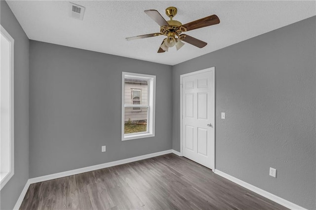 empty room featuring ceiling fan and dark wood-type flooring