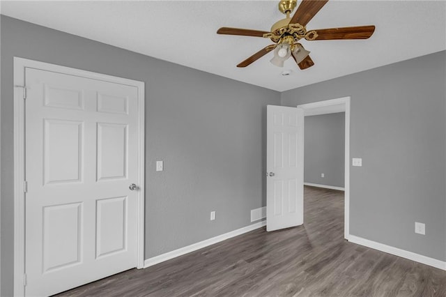 unfurnished bedroom featuring ceiling fan and dark hardwood / wood-style floors