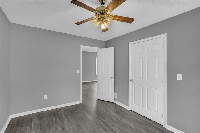 unfurnished bedroom featuring ceiling fan and dark hardwood / wood-style floors