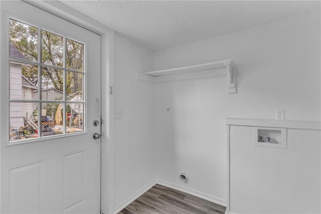 clothes washing area with hardwood / wood-style flooring, a wealth of natural light, a textured ceiling, and hookup for a washing machine