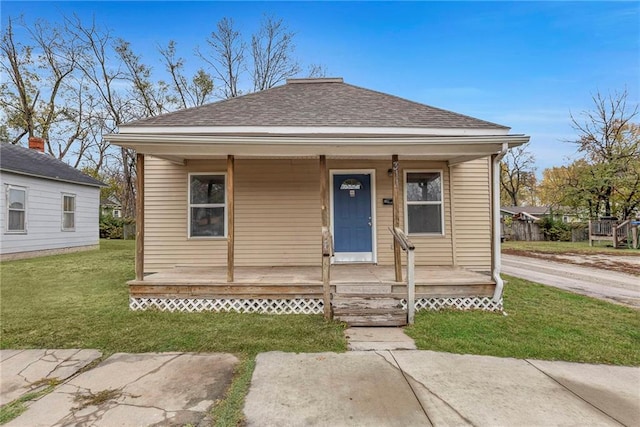 bungalow with a porch and a front lawn