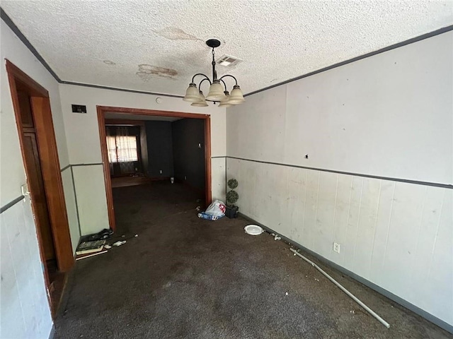 unfurnished dining area with a notable chandelier and a textured ceiling