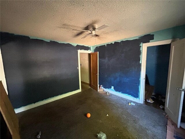 unfurnished room with ceiling fan and a textured ceiling