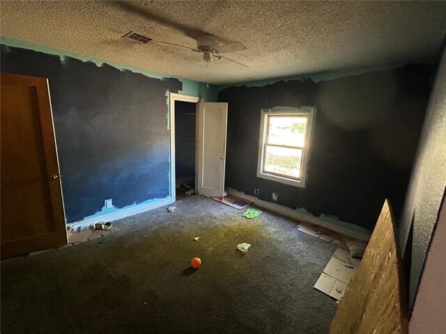 unfurnished bedroom with a textured ceiling, carpet flooring, and ceiling fan