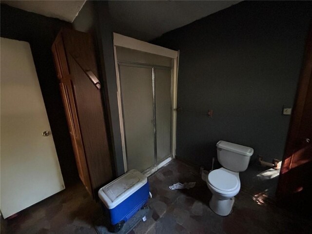 bathroom featuring toilet and an enclosed shower