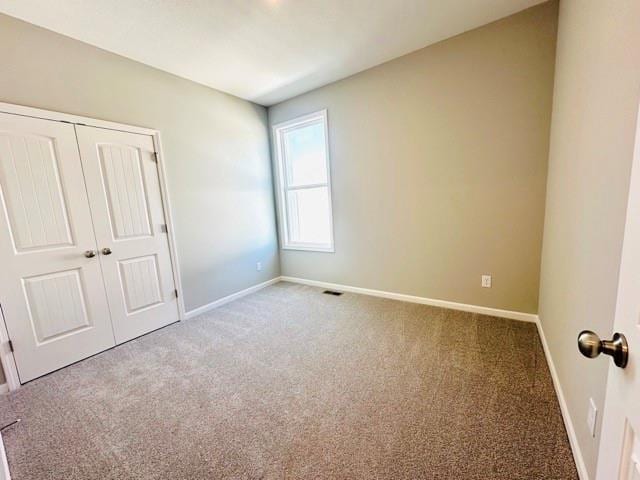 unfurnished bedroom featuring carpet floors and a closet