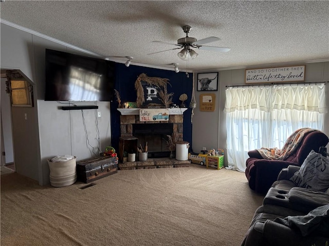 carpeted living room featuring ornamental molding, a textured ceiling, ceiling fan, and a fireplace