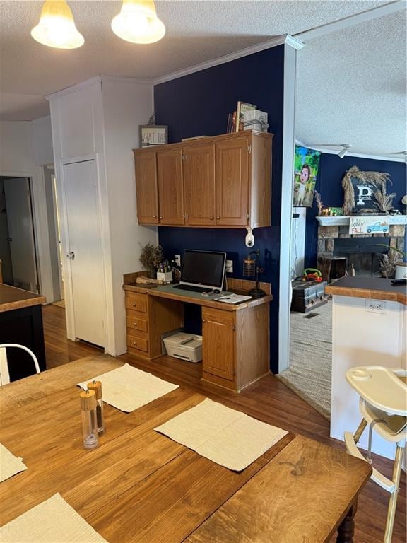 kitchen with ornamental molding, light hardwood / wood-style floors, and a textured ceiling