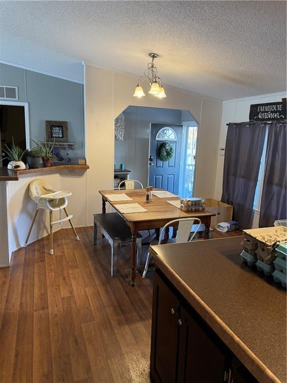 dining room with hardwood / wood-style flooring, a chandelier, a textured ceiling, and lofted ceiling