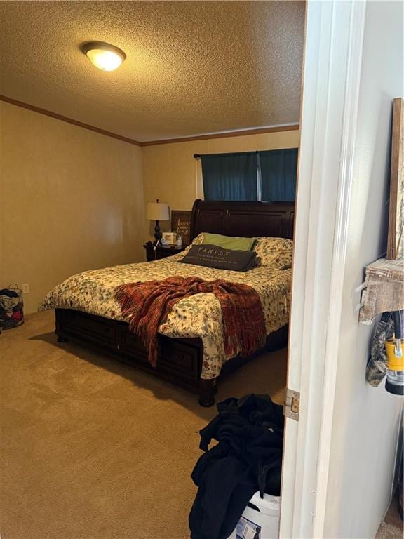 bedroom with a textured ceiling, crown molding, and carpet floors