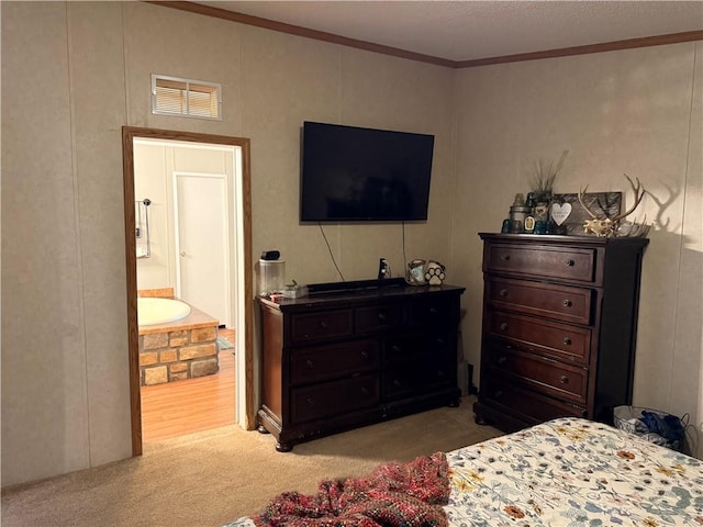 carpeted bedroom with crown molding and ensuite bath