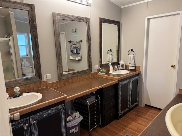 bathroom featuring ornamental molding, vanity, hardwood / wood-style flooring, and toilet