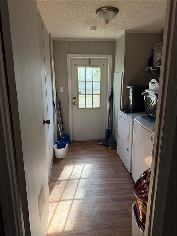 laundry room with washing machine and clothes dryer, light hardwood / wood-style floors, and a textured ceiling