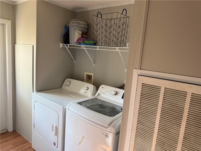 washroom with independent washer and dryer, hardwood / wood-style flooring, and a textured ceiling